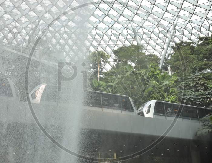 train passing by waterfalls atAt Jewel Changi Airport, Singapore