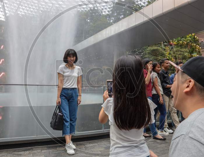 Tourists At Vortex Water Fall At Jewel Changi Airport, Singapore