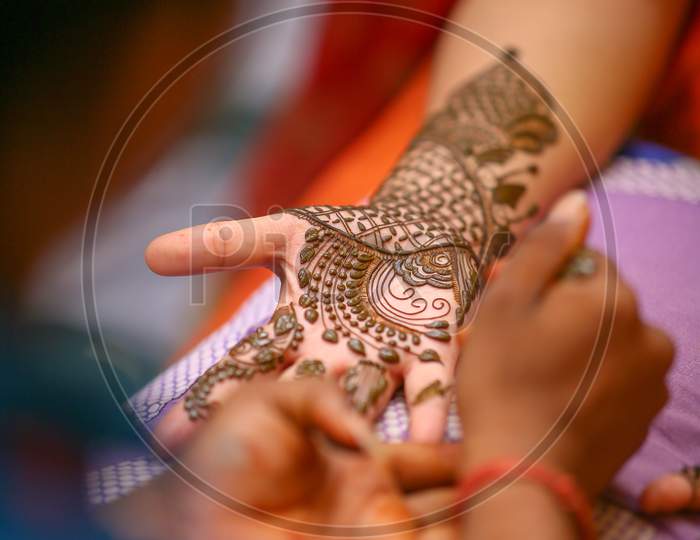 Mehndi  Artists  Making a Mehndi Design on Bridal hands on Her Wedding Day