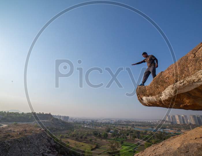 Indian tourist standing on the cliff with his hand open