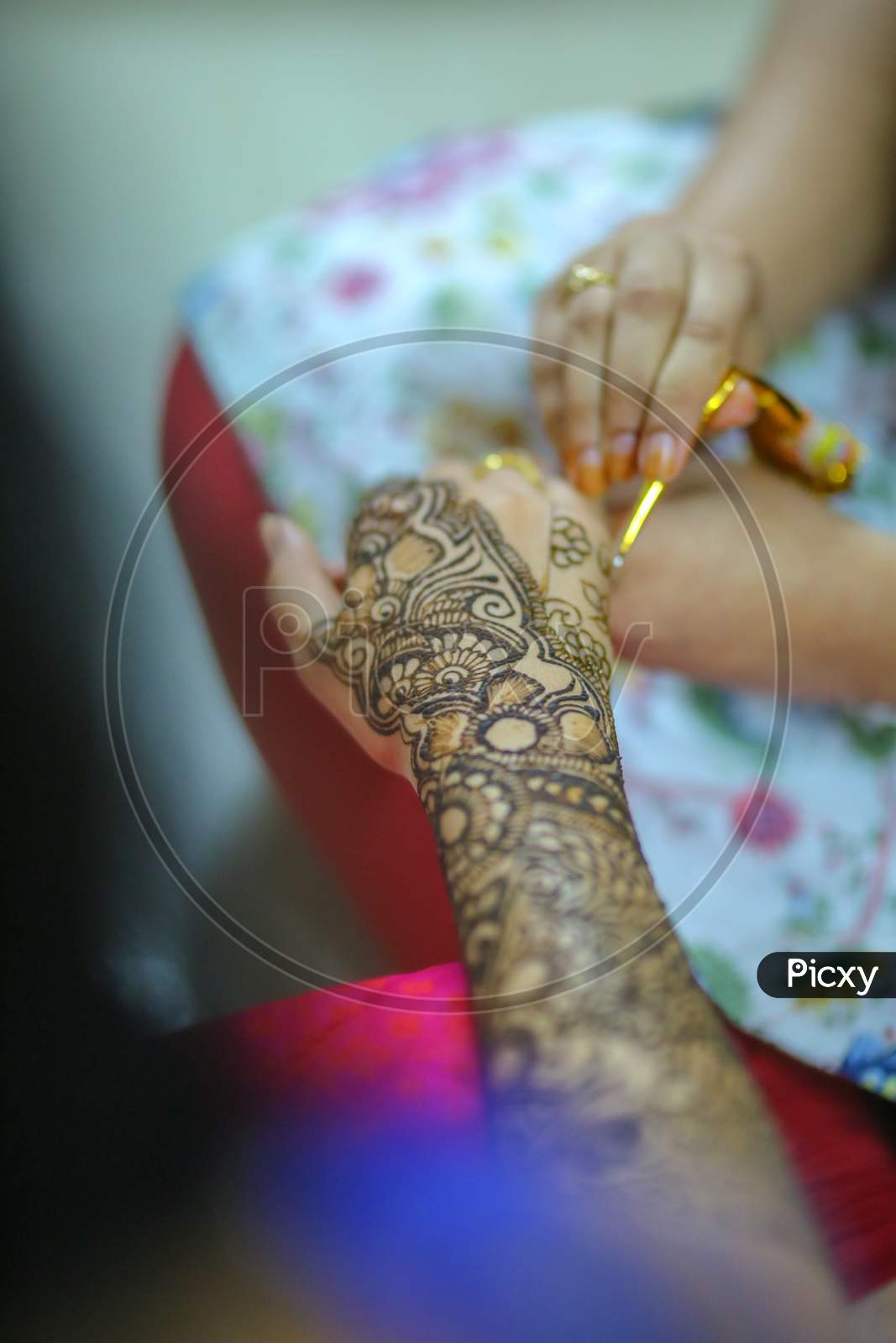 Mehndi Artist Making Design on Bride's Hands On Her Wedding Day