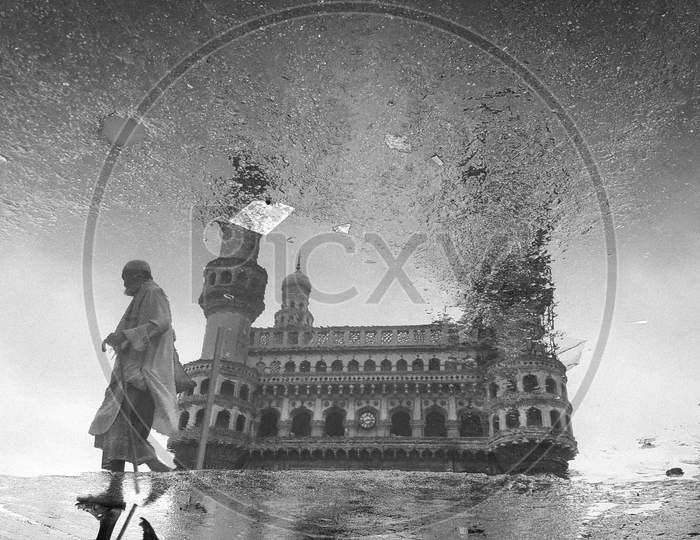 An Old Man Reflection On Water Surface At Charminar