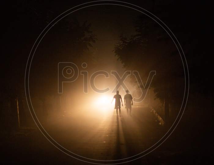 Two men walking during the night