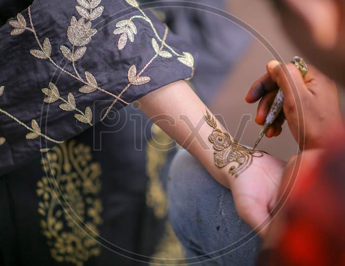 Mehndi Artist Making Design on Bride Hands On Her Wedding Day