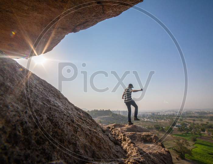 Indian man jumping on the boulder