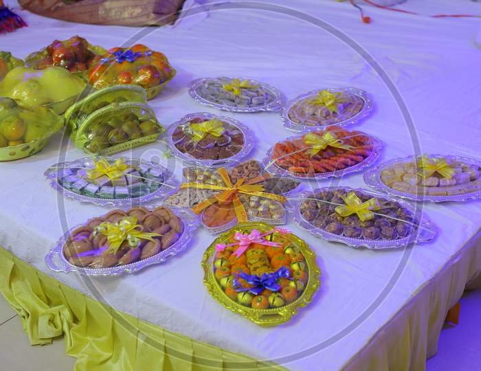 Traditional Plates in an Indian Wedding Ceremony With Sweets And Fruits Wrapped