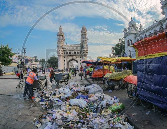 Indian sanitary worker picking the trash by the Charminar