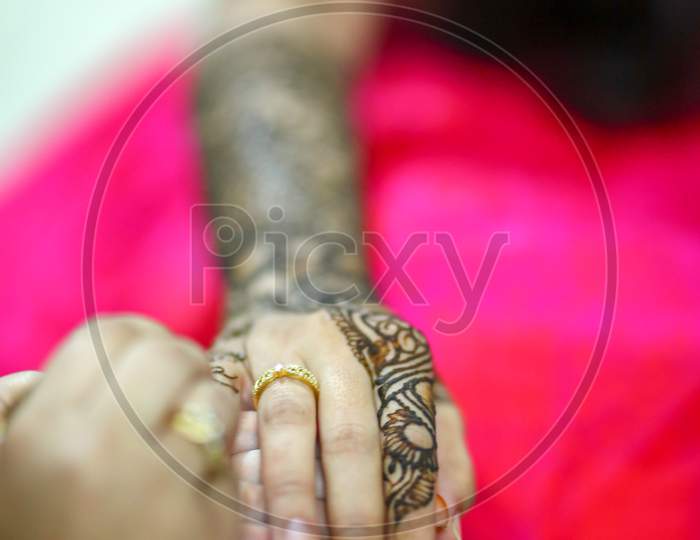 Mehndi Artist Making Design on Bride's Hands On Her Wedding Day