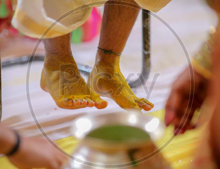 South Indian Wedding Rituals With Groom Legs  Applied With turmeric Paste  At Wedding Ceremony