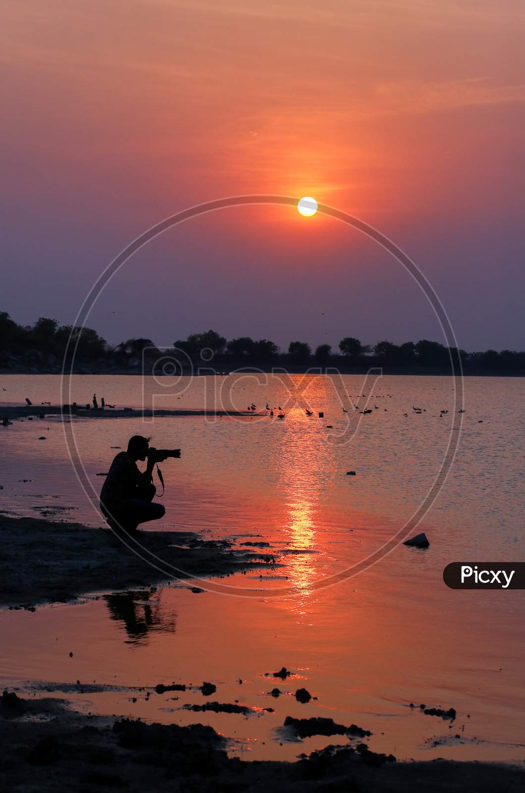 Silhouette of Indian Photographer shooting during sunset