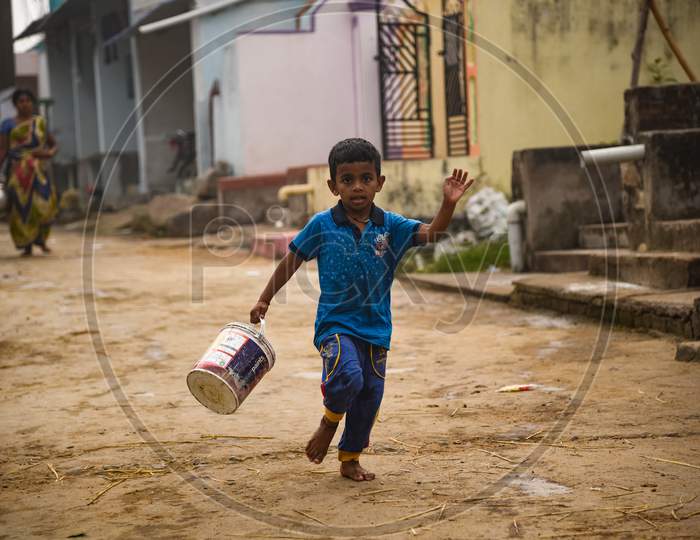 Child carrying bucket to bring water