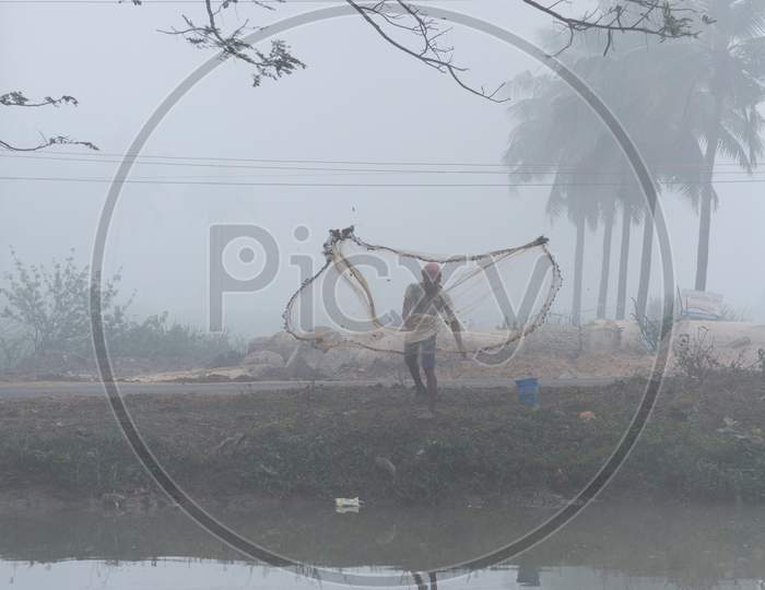 A Fisherman throwing cast net during early morning