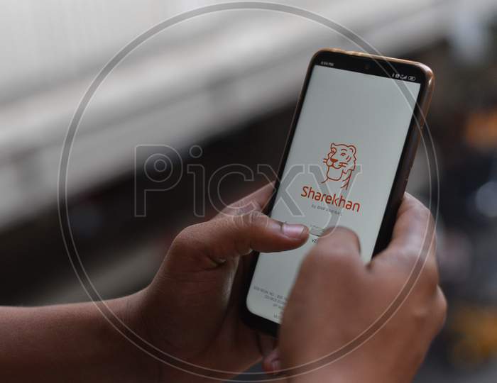 Indian man opening ShareKhan app on the andriod phone