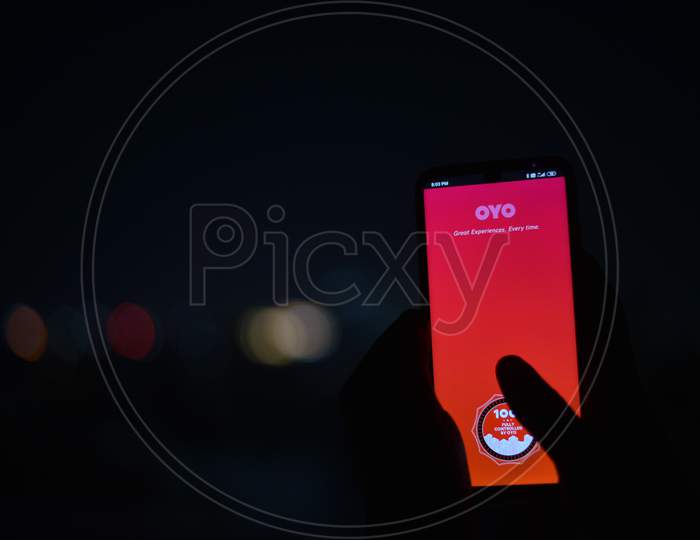 Indian man using OYO rooms app in the dark