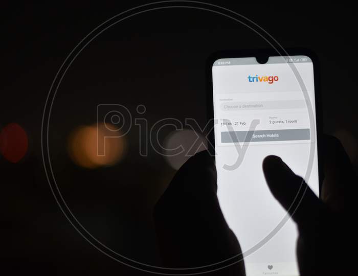 Indian Man using Trivago App in the dark