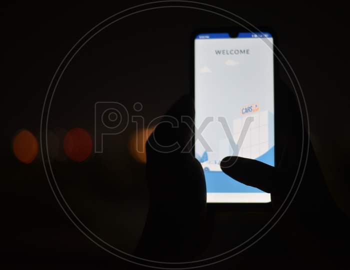 Indian Man using Cars24 app in the dark