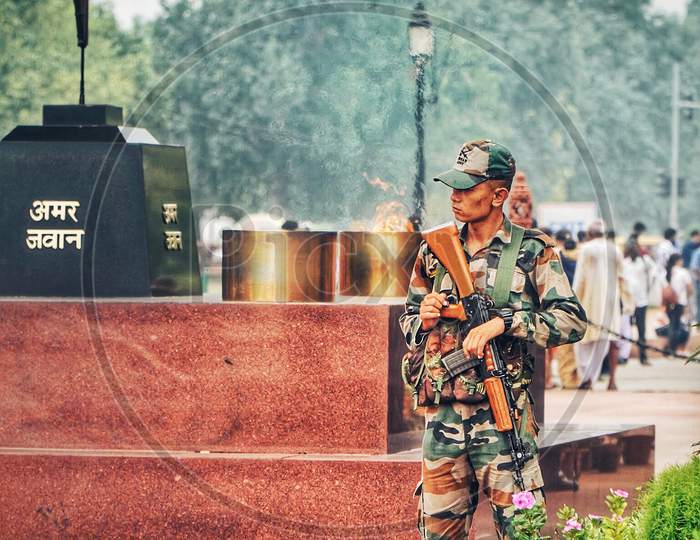 A Army Man At India Gate With a Gun