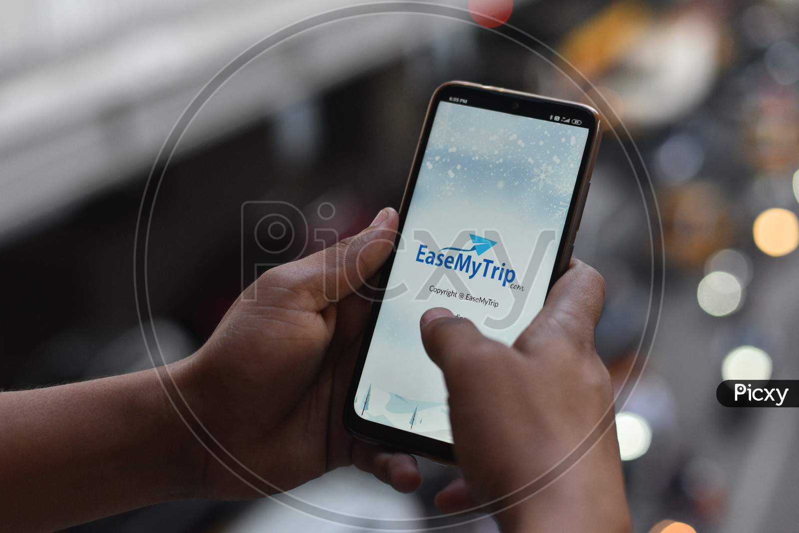 Indian Man opening EaseMyTrip.Com mobile app