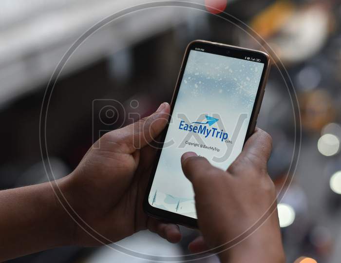 Indian Man opening EaseMyTrip.Com mobile app