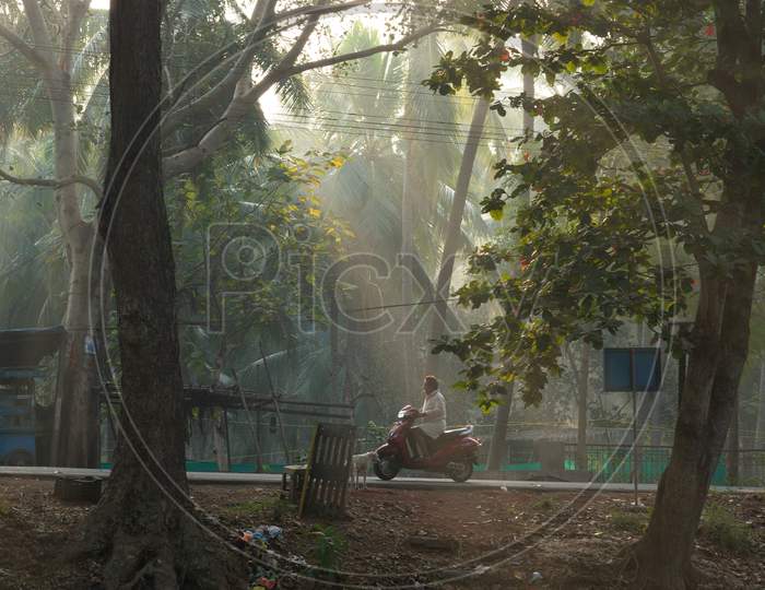 View of Indian Man riding scooty during morning