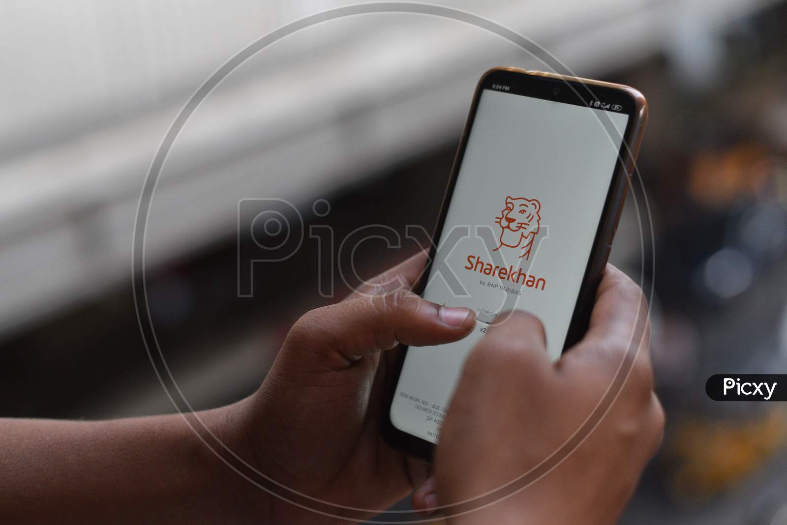 Indian man opening ShareKhan app on the andriod phone