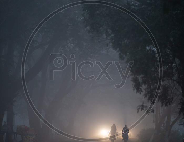 Village riding bicycle during foggy morning