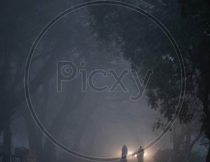 Villagers moving along the foggy road
