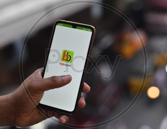 Indian man opening Big Basket app on the android phone
