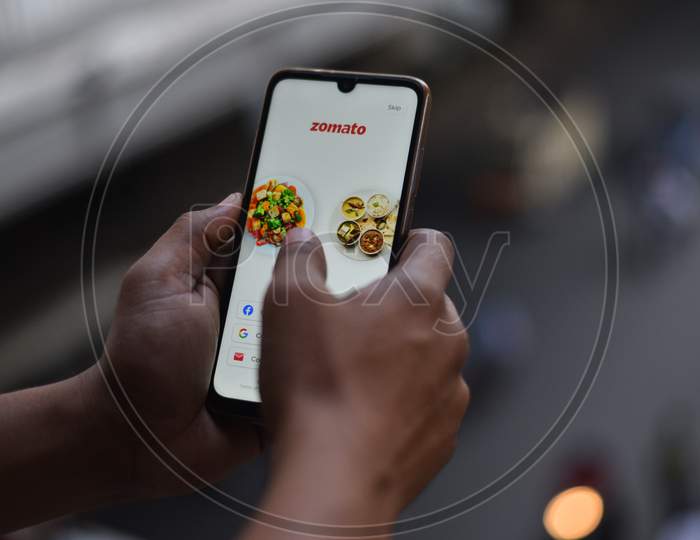 Indian man using Zomato food delivery app to order food