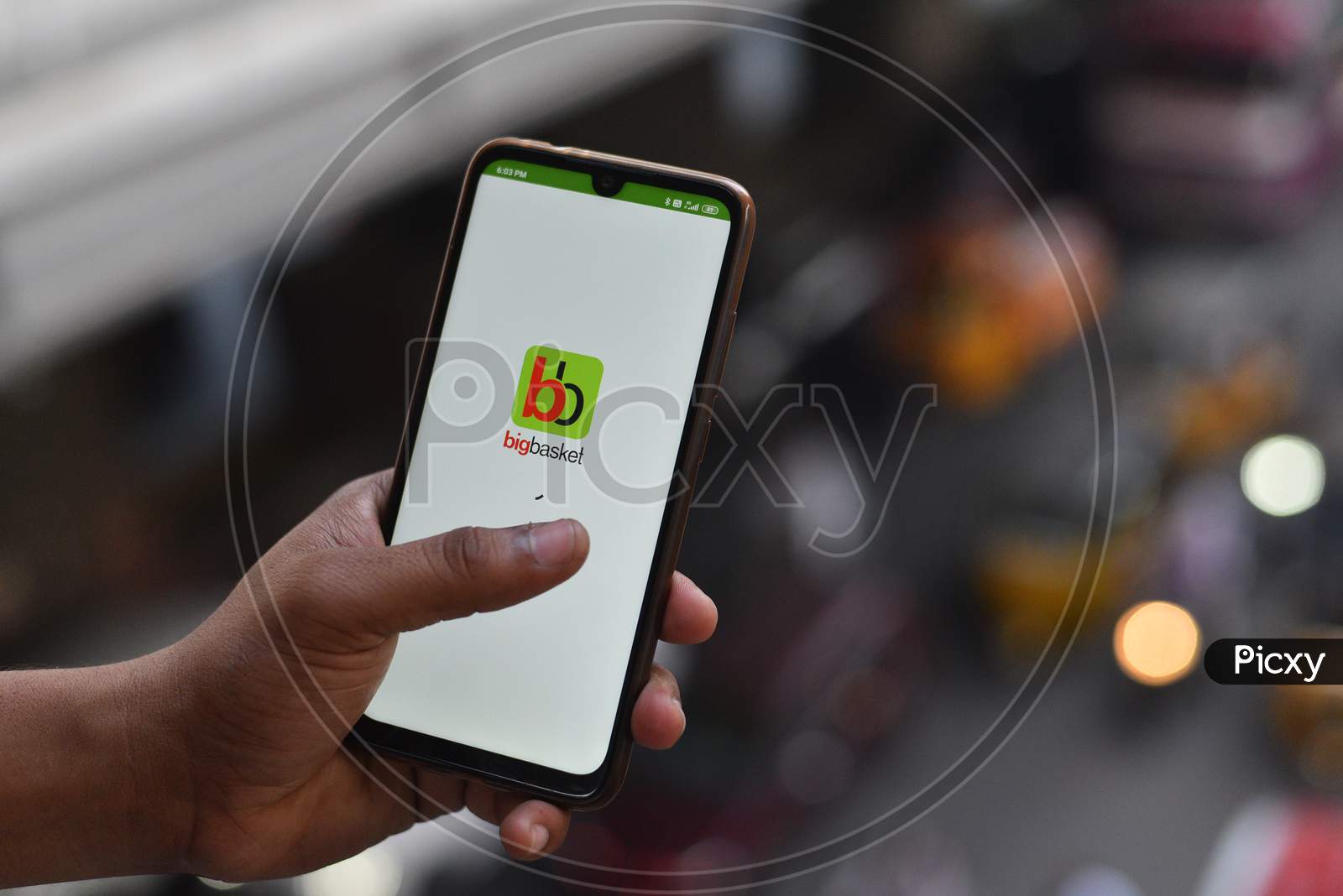 Indian man opening Big Basket app on the android phone
