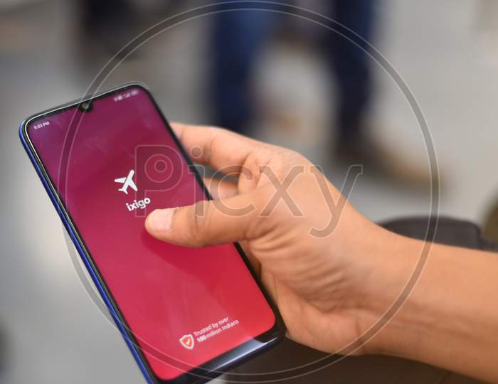 Indian Man using ixigo app on the phone