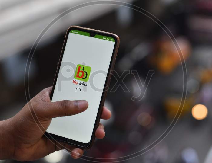 Indian Man installing Big Basket app on the phone