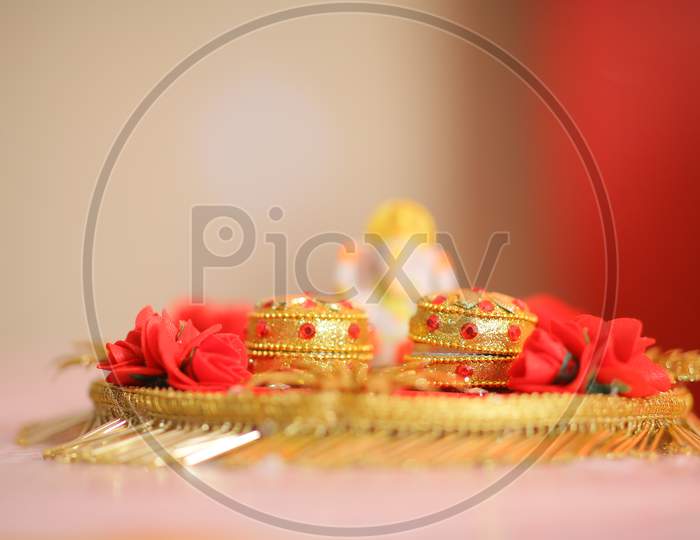 View of Indian Wedding rings in a gold container during puja