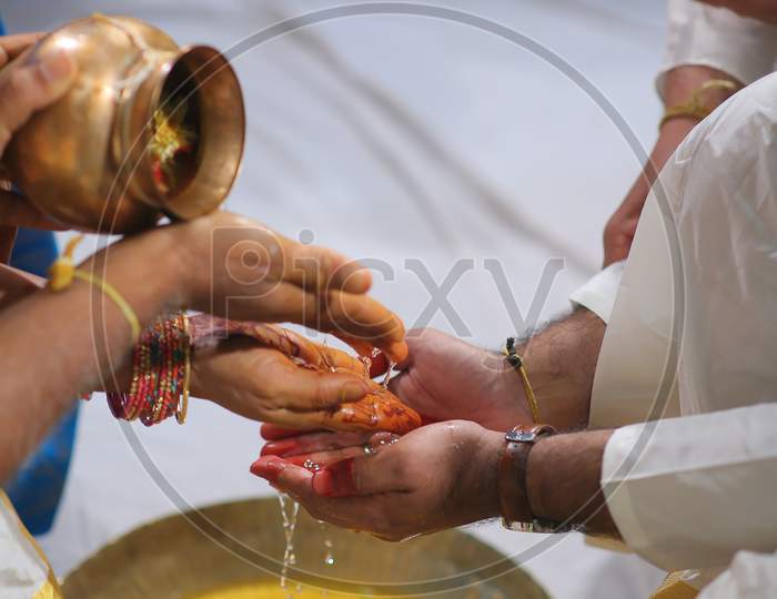 South Indian Bride Groom washing hands during wedding puja