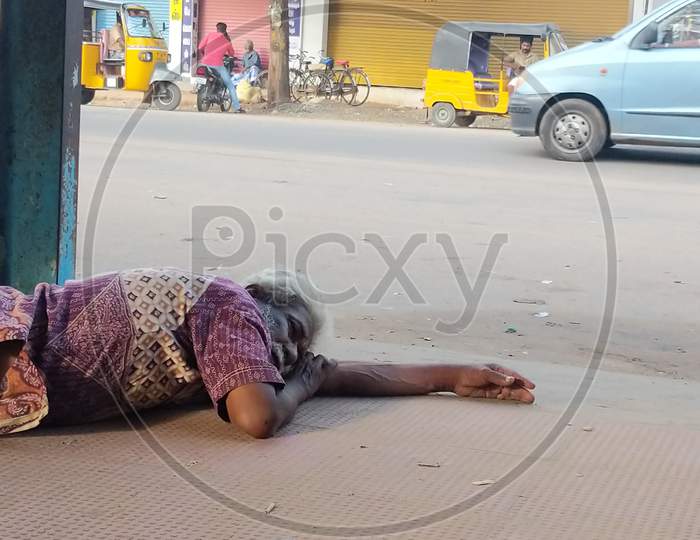 Indian beggar man sleeping on the road