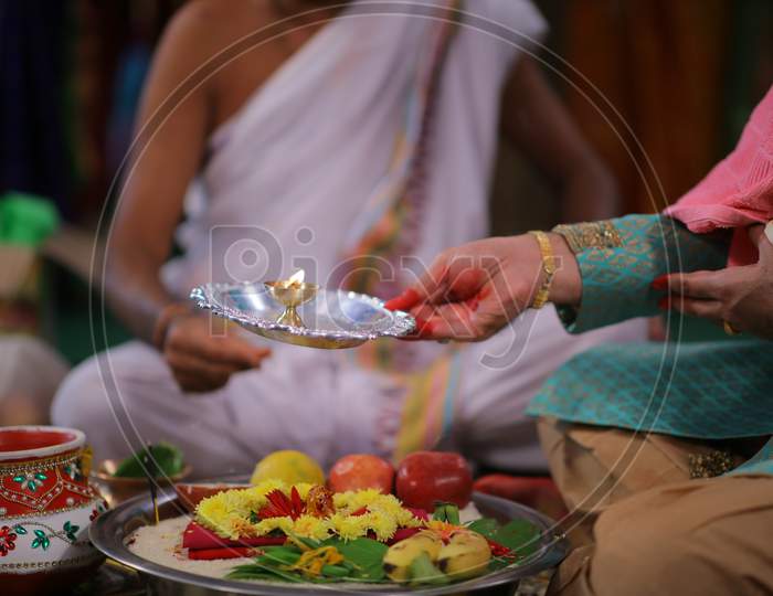 Indian bride groom holding oil lamp during puja