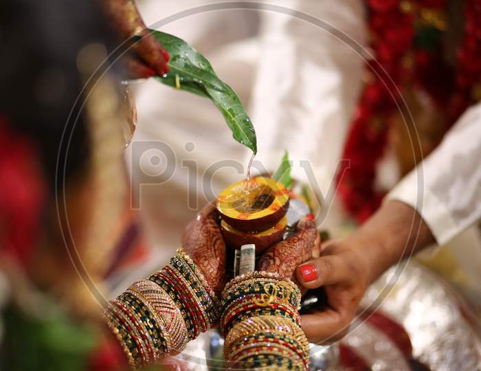Indian bride holding dried coconut with sacred water