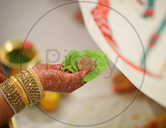 Indian bride holding Cumin and jaggery