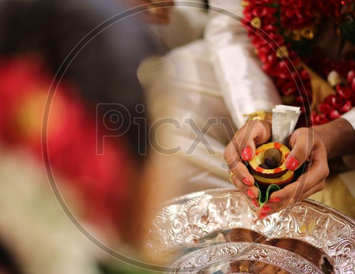 Indian Bride Groom holding dried Coconut during wedding