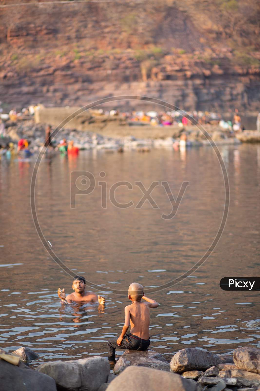 Indian little boy playing with his father by the river