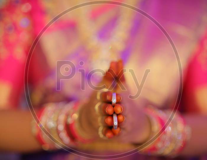 South Indian bride holding diamond rings in her hand