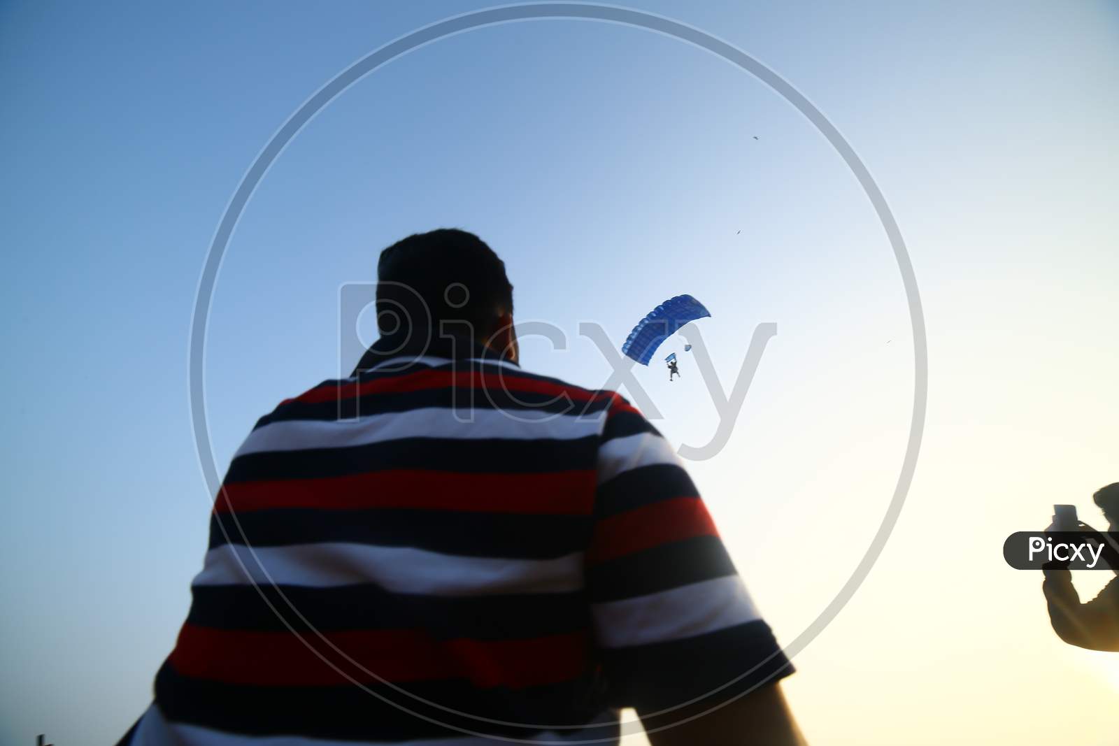 Indian man spectating the paragliding