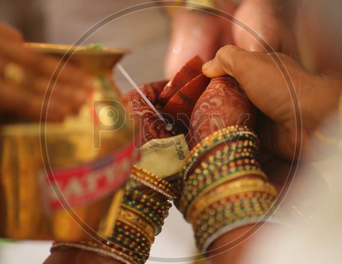 South Indian Bride holding money during Wedding Puja