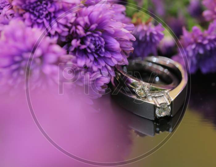 Couple Wedding Rings With Flowers Background