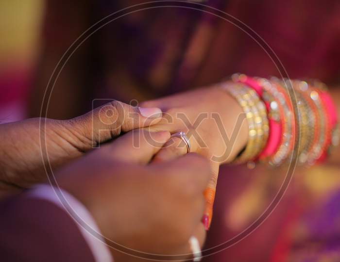 Indian bride groom putting ring during engagement