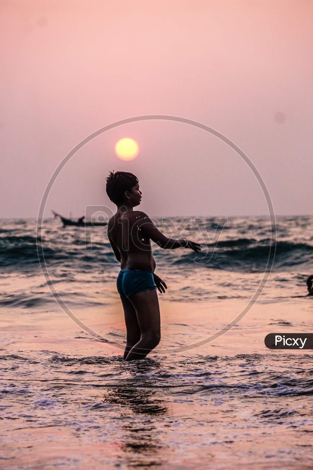 Indian kid playing in the Goa beach during sunset