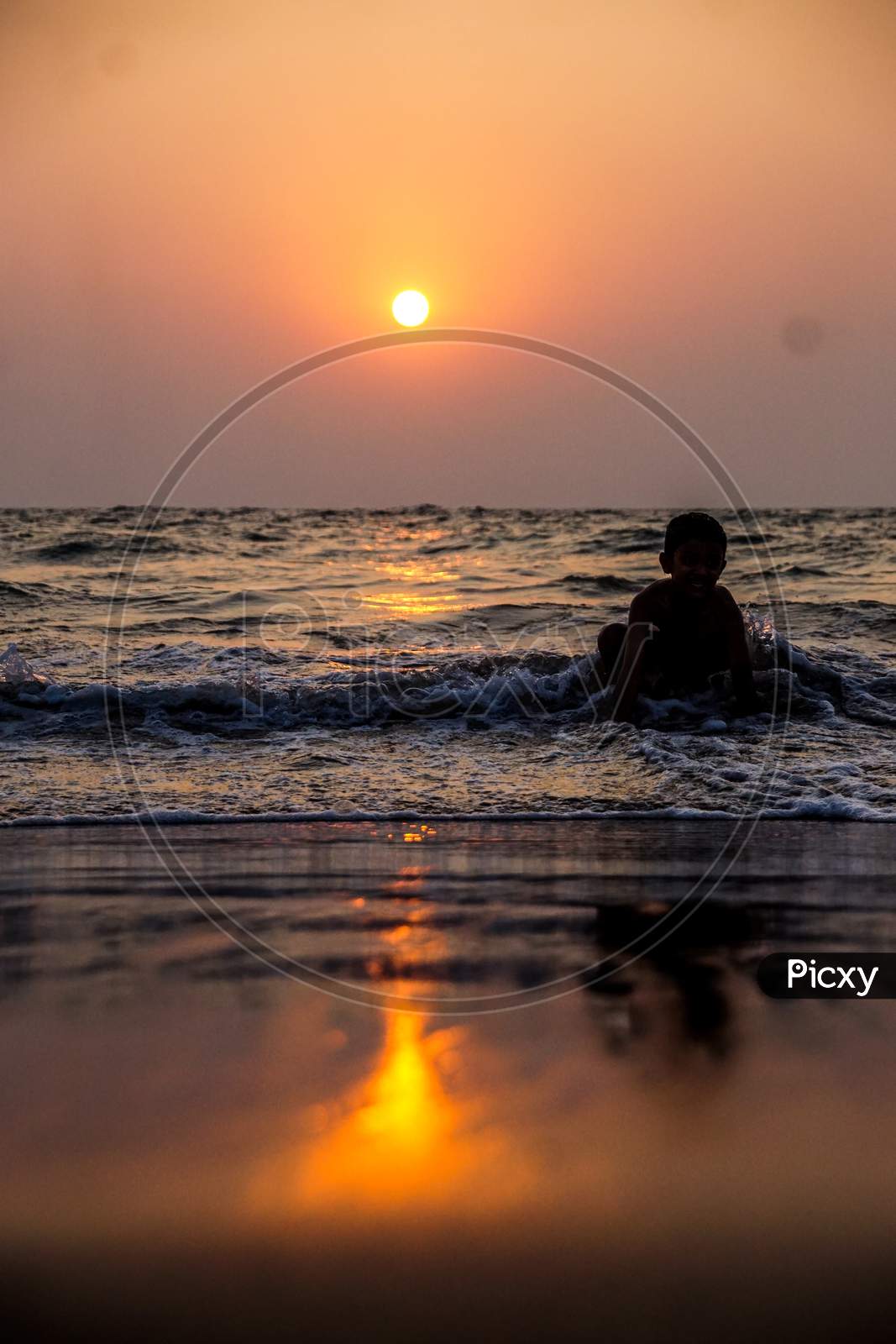 Indian little kid playing in the goa beach during sunset