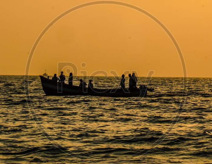 Indian fishermen in fishing boat during sunset
