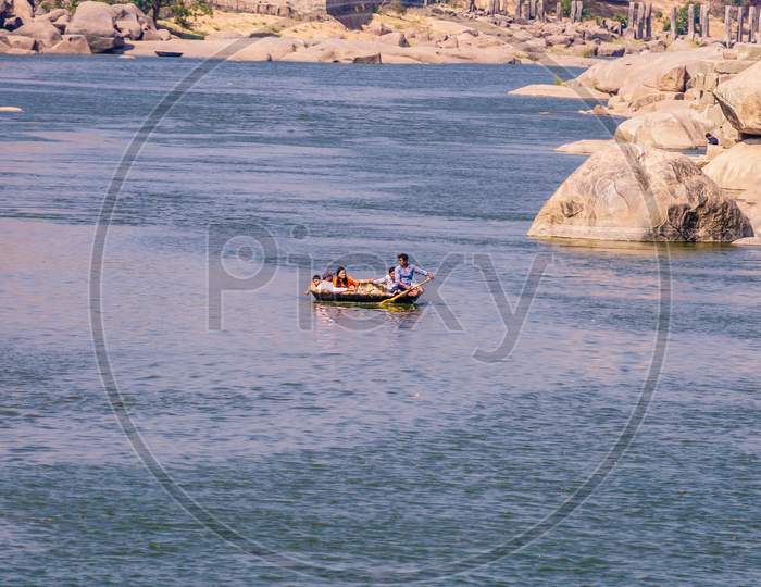 Tourists enjoying coracle boat ride in Hampi