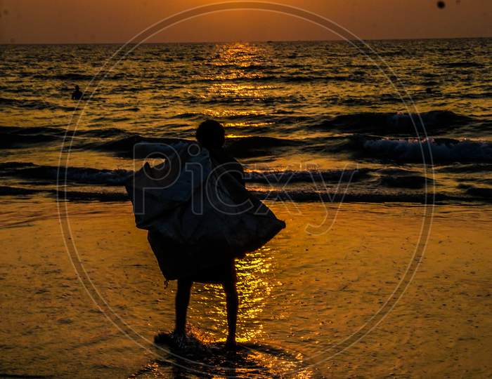Indian man during sunset by the Goa beach